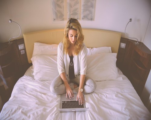 A person typing on a laptop looking relaxed